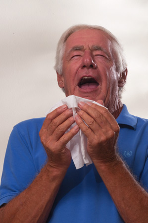 Man Sneezing into Tissue 
